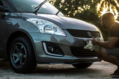 man washing silver car