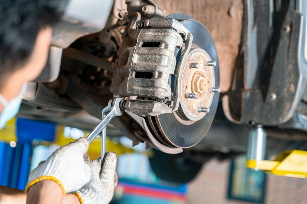 person working in car brakes